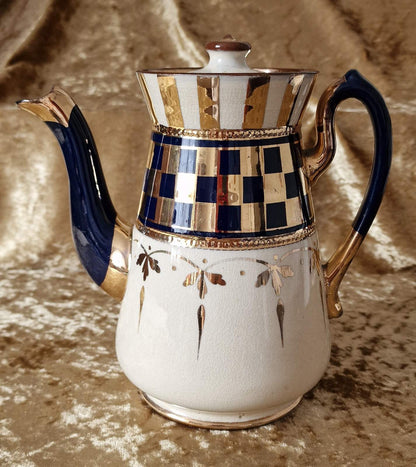 A classic white and blue teapot adorned with elegant gold trim. Perfect for a traditional tea time gathering.