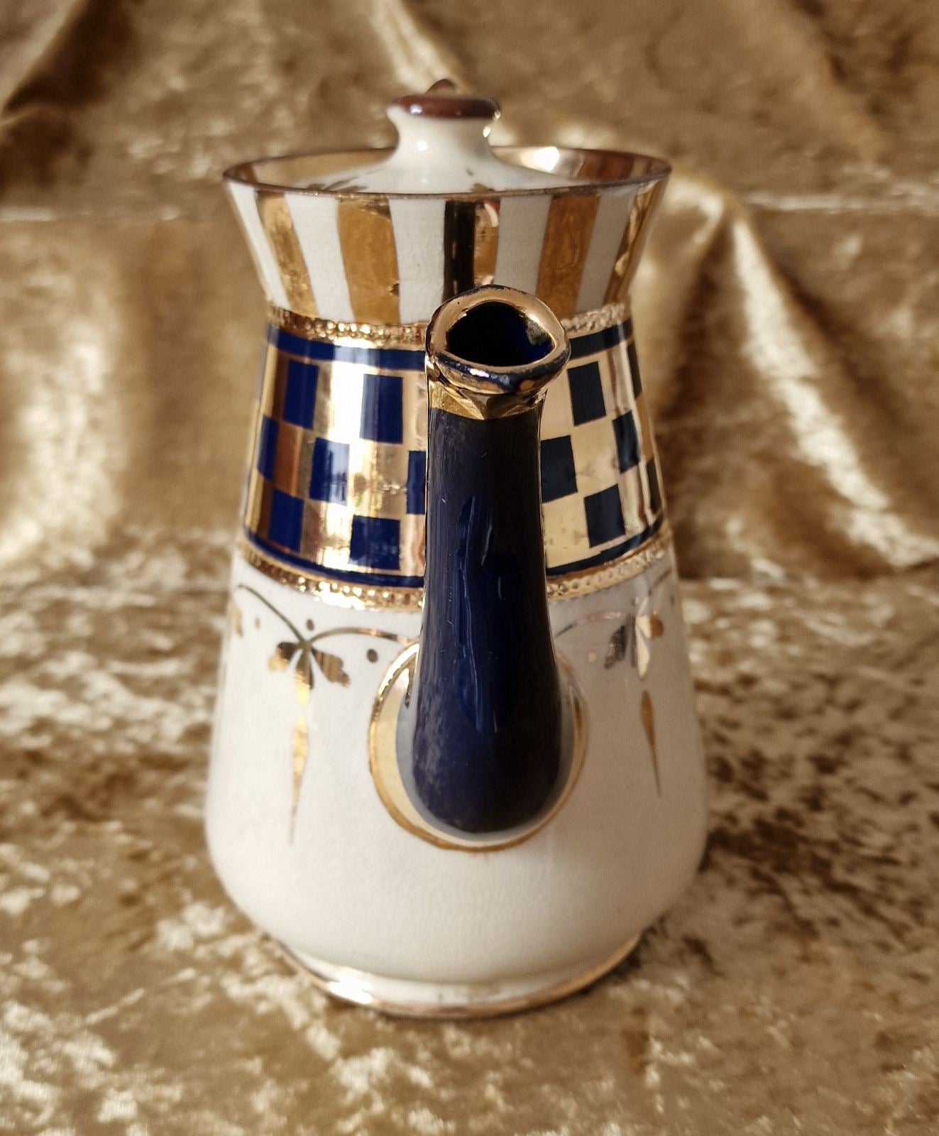 A classic white and blue teapot adorned with elegant gold trim. Perfect for a traditional tea time gathering.