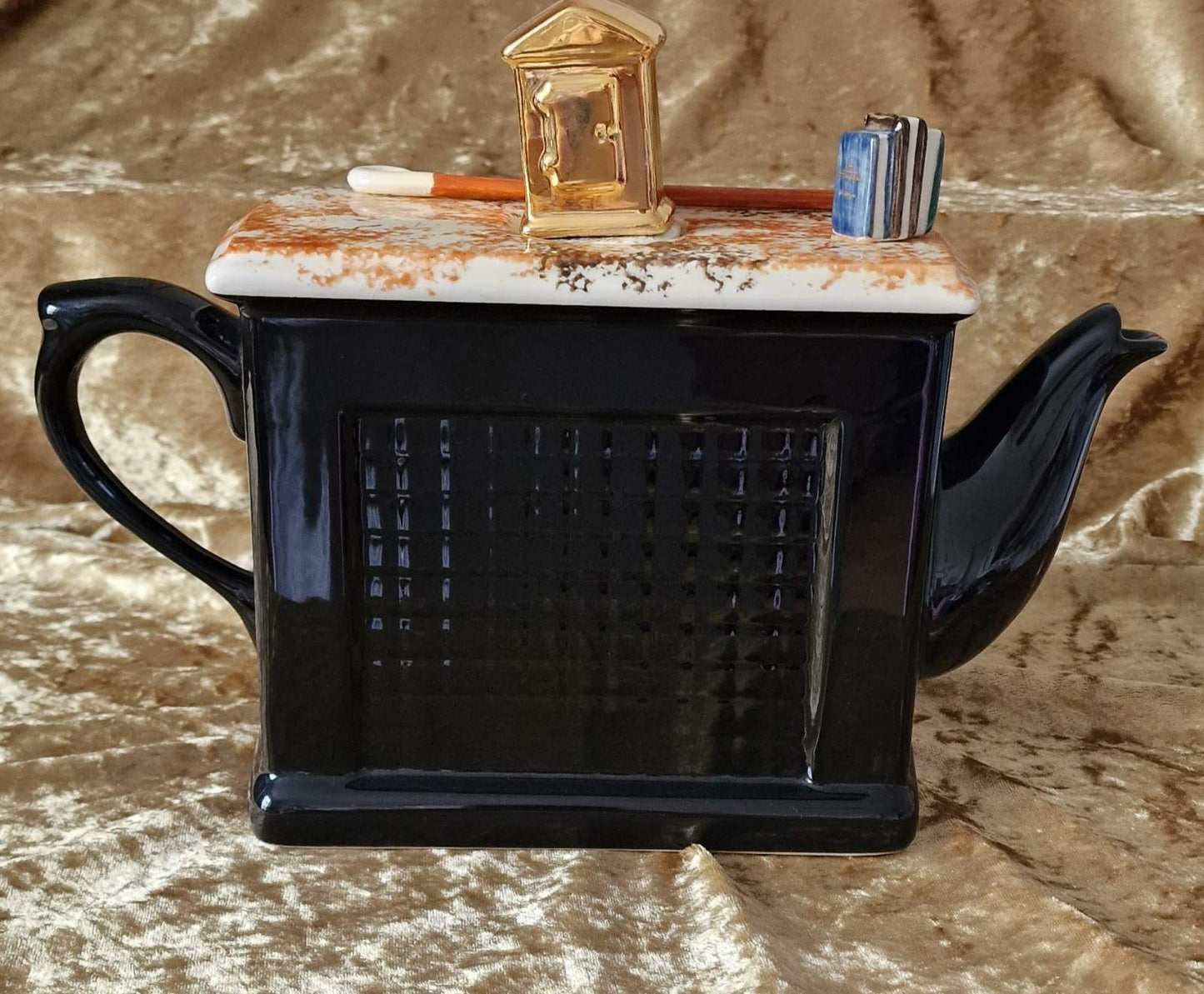 Unique black teapot with fireplace and clock, a prized collectible from Teapottery Company in Yorkshire.